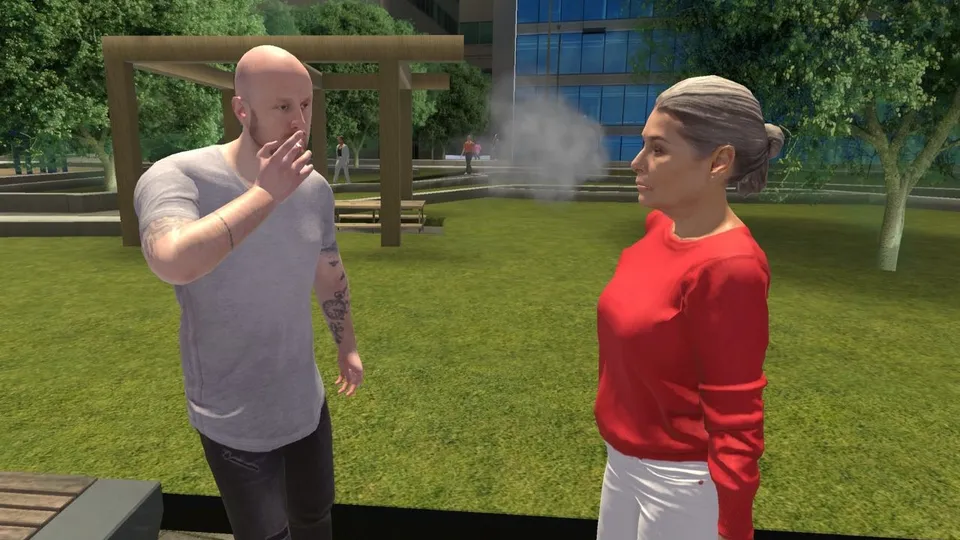 A person smokes in front of another person in a park