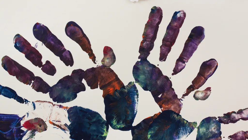 Handabdrücke aus mehrfarbiger Farbe auf weißem Papier