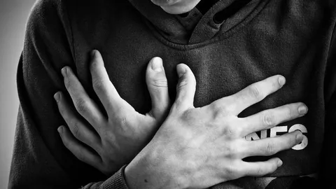 Eine Person hält sich während einer Panikattacke die Brust