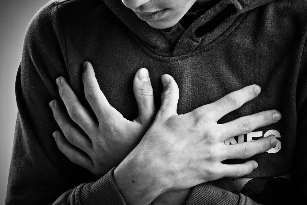 Eine Person hält sich während einer Panikattacke die Brust