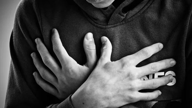 Eine Person hält sich während einer Panikattacke die Brust