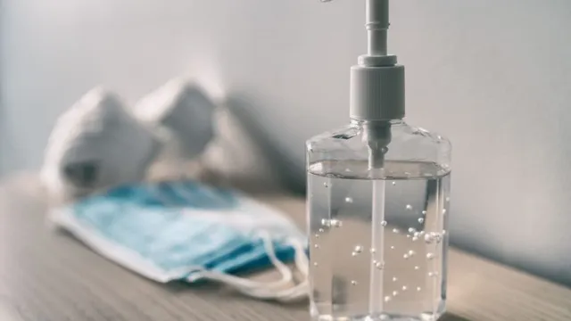 Flasche Handdesinfektionsmittel mit Maske im Hintergrund