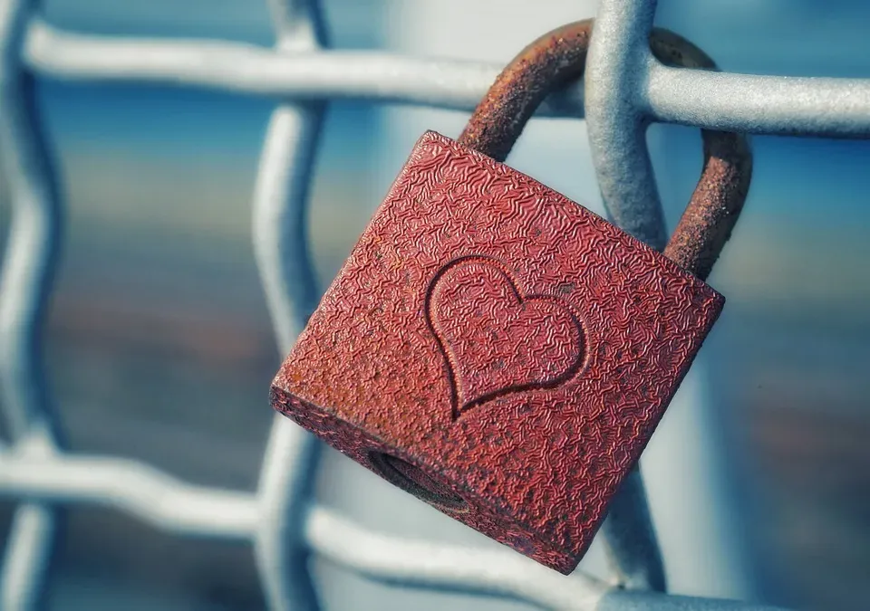 Red heart-shaped padlock attached to a railing