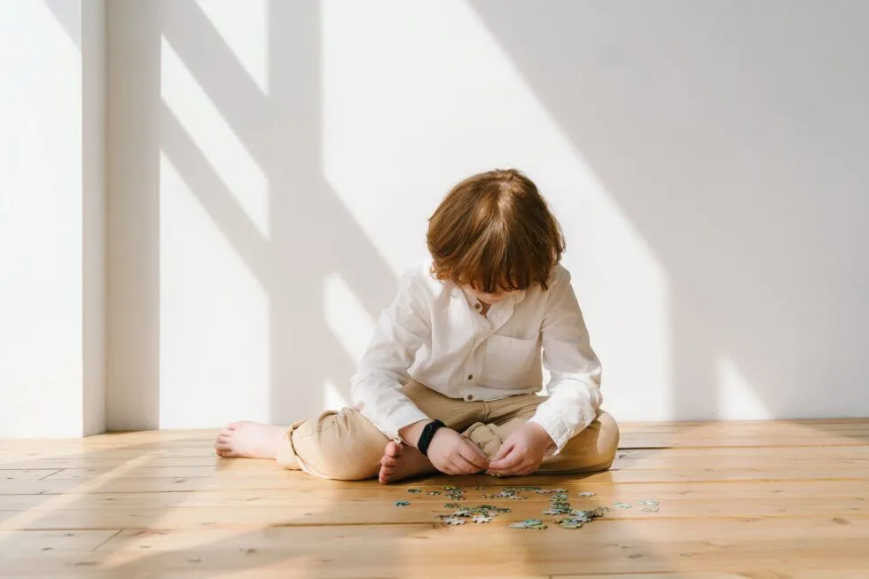 A child sits alone in a bright room