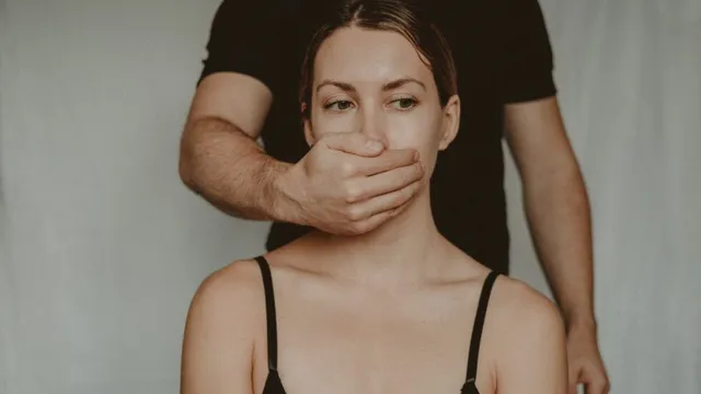 Eine Hand bedeckt den Mund einer Frau