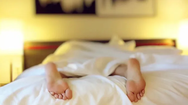 Zwei Personen liegen unter einer Decke, ihre Füße sind sichtbar