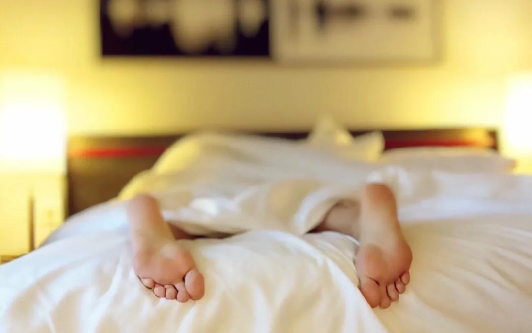 Zwei Personen liegen unter einer Decke, ihre Füße sind sichtbar