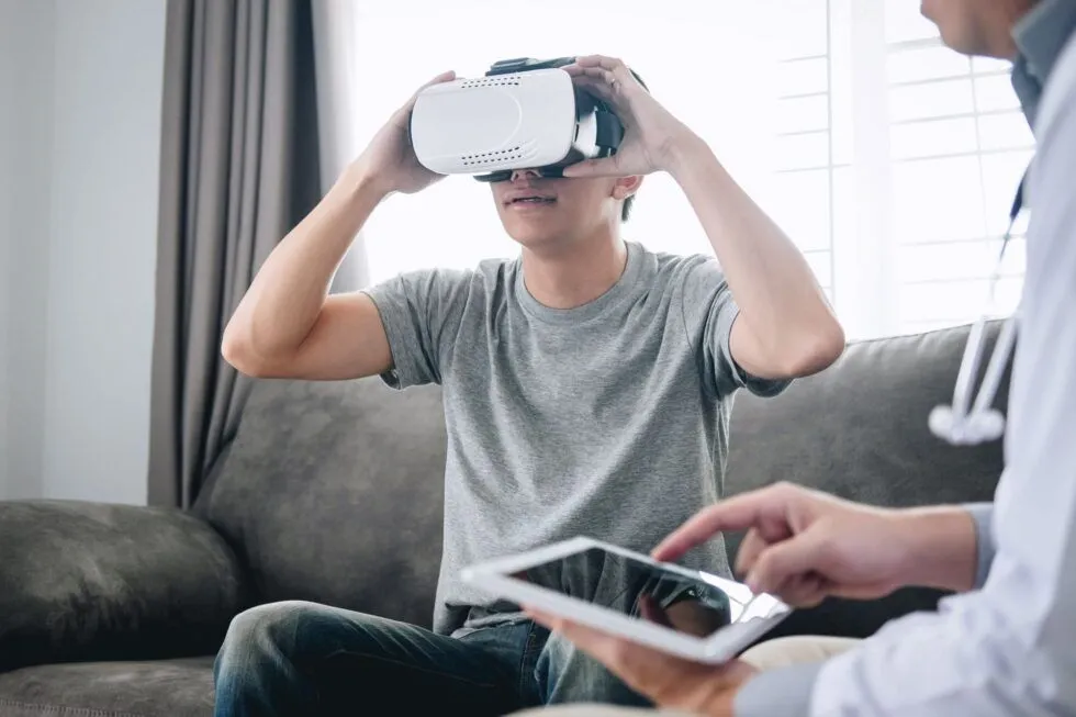 Une patiente utilise un casque de réalité virtuelle avec une thérapeute